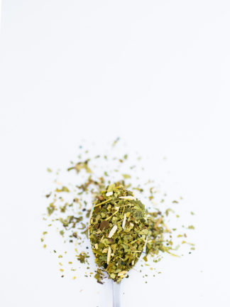 Bright green chopped leaves decorate a silver spoon
