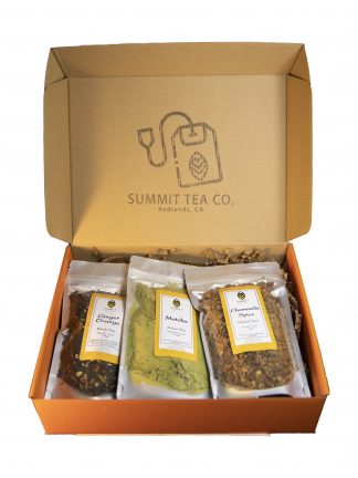 Orange flat gift box and hinged lid with a large rubber stamped Summit Teabag on the underside of the lid with 3 four ounce teas in bags slightly overlapping