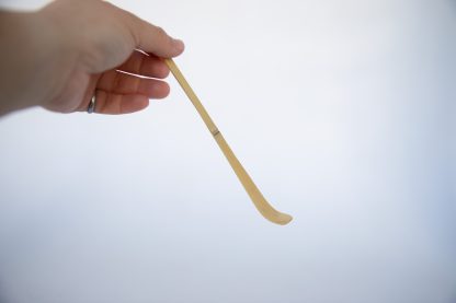 Hand holding a bamboo matcha scoop